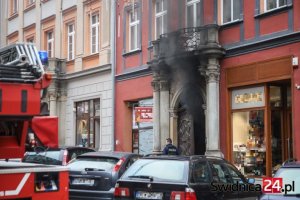 pożar pomieszczeń piwnicznych w budynku ul. Grodzka. Przed kamienica stoi policjant