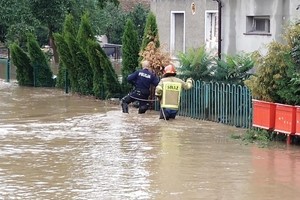 Policjanci pomagają mieszkańcom, którzy ucierpieli w wyniku intensywnych opadów deszczu