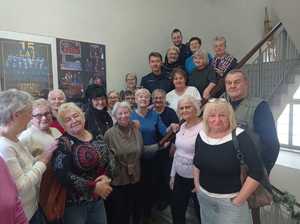 grupa seniorów stojąca na schodach a między nimi 2 policjantów