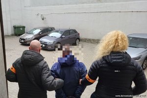 dwoje policjantów prowadzi osobę zatrzymaną