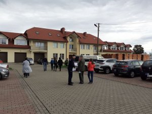 policjant rozdaje ulotki z apelem jak nie paść ofiarą oszustów na placu przed kościołem ul. Rolnicza w Świdnicy