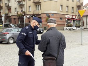 policjant rozmawia z seniorem na temat oszust metodą &quot;na wnuczka&quot;